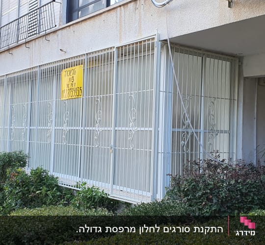 סורגים לבנים על חלונות עם שלט צהוב